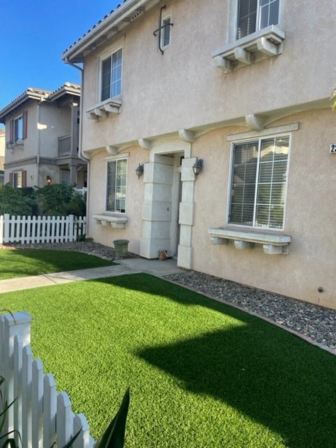 A house with a white picket fence and a green lawn.