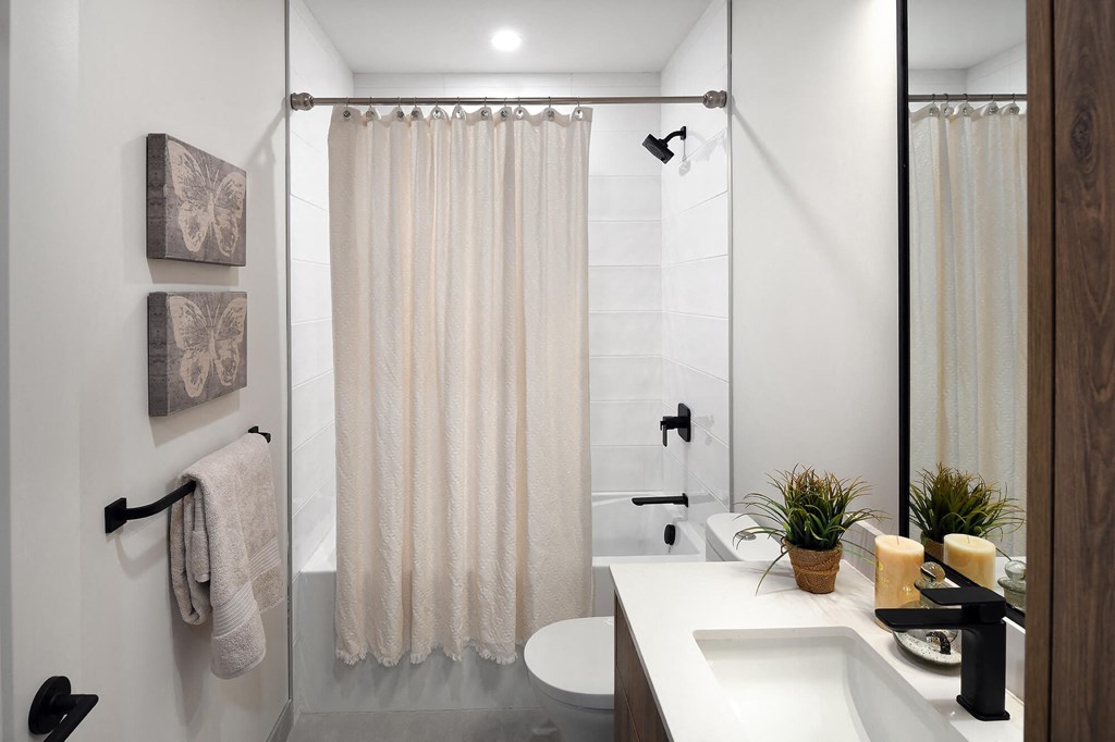 a bathroom with a shower and a sink and a toilet