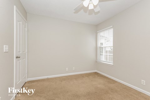 a bedroom with a carpeted floor and a ceiling fan