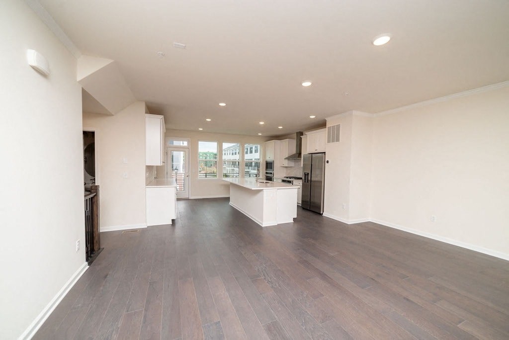 a large living room with a kitchen and a table