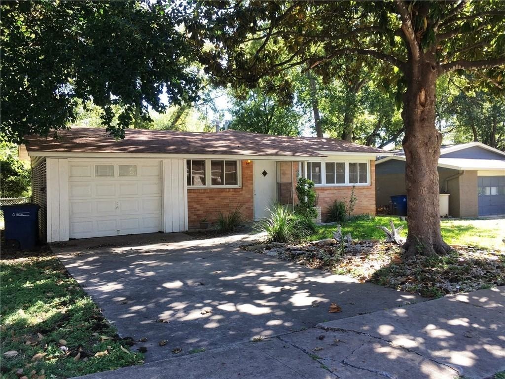 a house with a white garage door and a tree