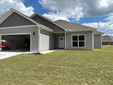 a gray house with a yard in front of it