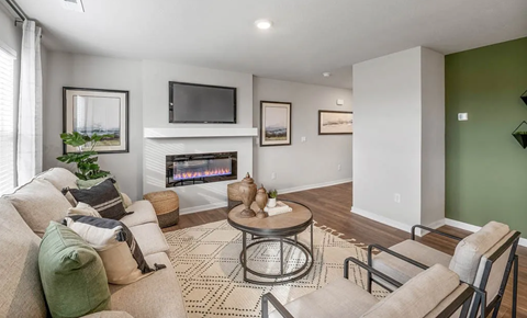 A living room with a fireplace and a television on the wall.