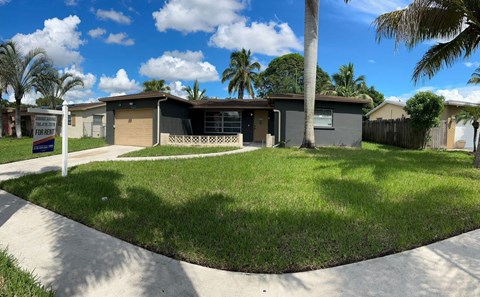 a house with a lawn and palm trees