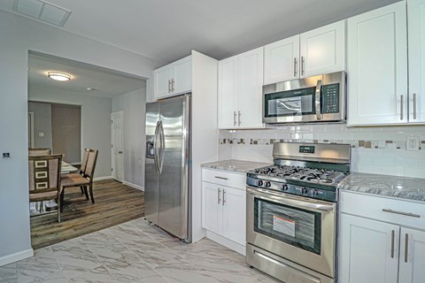 A kitchen with white cabinets and stainless steel appliances.