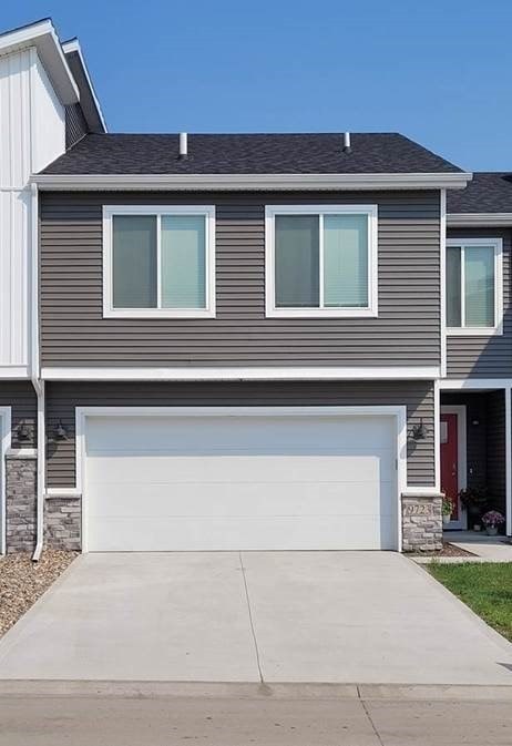 A grey house with a white garage door.