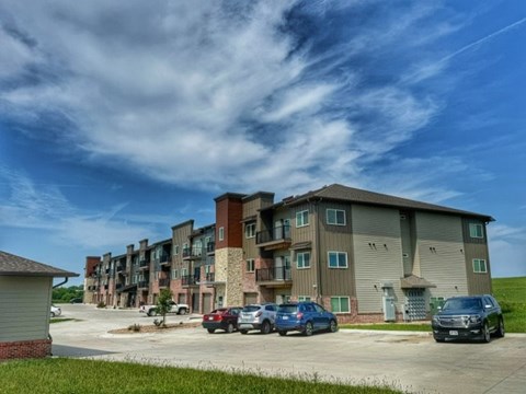 Apartment complex with cars parked in front.