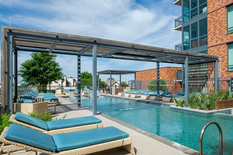 A pool area with sun loungers and a metal pergola.
