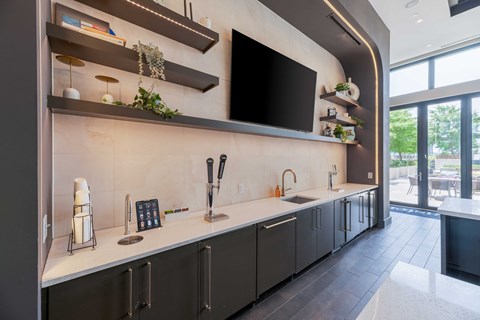 A modern kitchen with dark cabinets and a black countertop.
