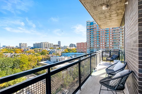 a balcony with two chairs and a view of the city