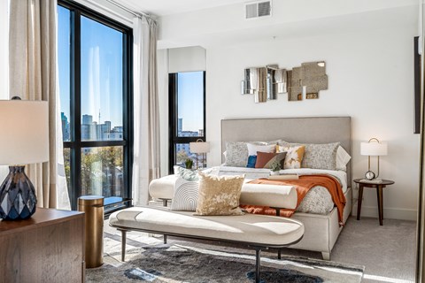 a bedroom with a bed and a large window