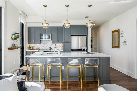 a kitchen with an island and gold bar stools