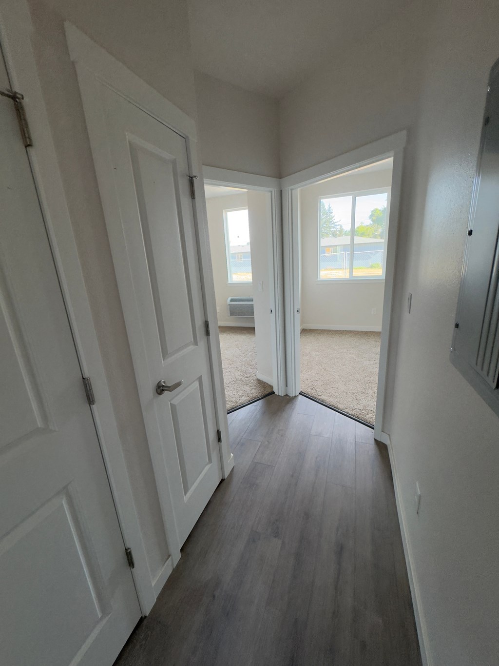 a bedroom with two closets and a hallway with two doors and a window