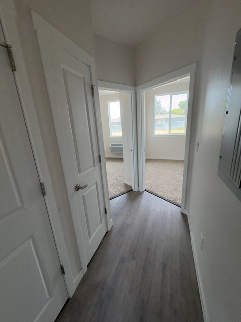 a bedroom with two closets and a hallway with two doors and a window
