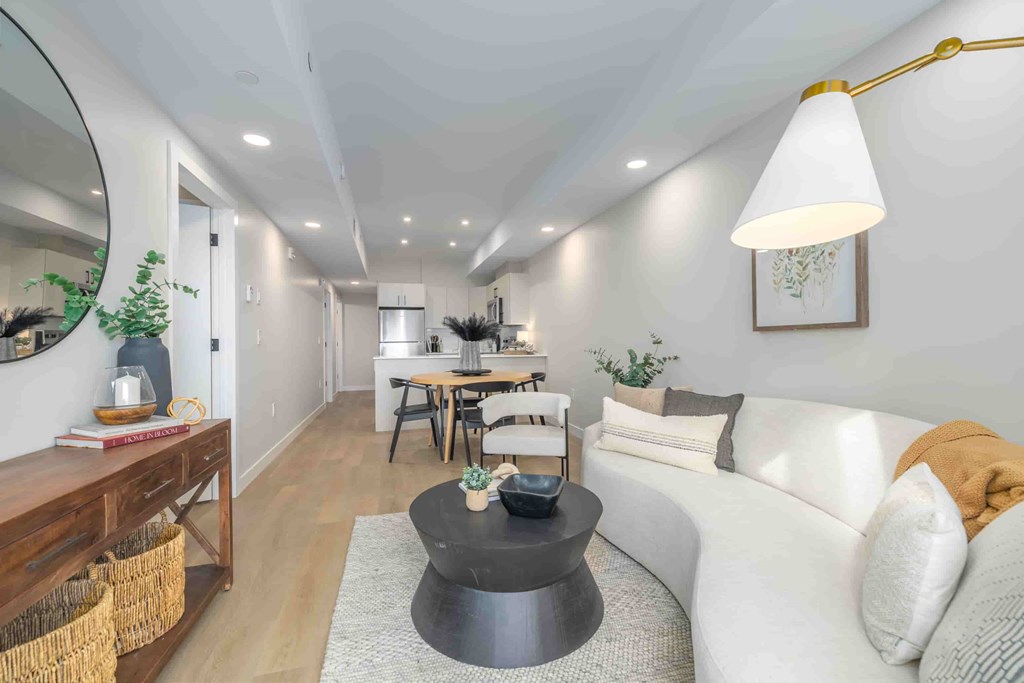 A modern living room with a white sofa and a black coffee table.