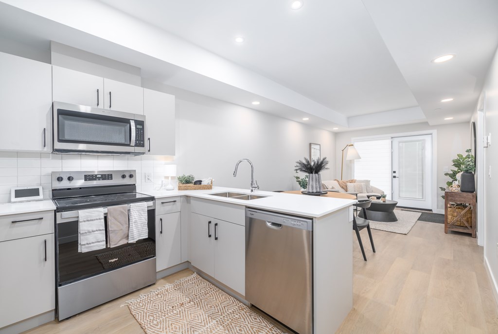 A modern kitchen with stainless steel appliances and white cabinets.