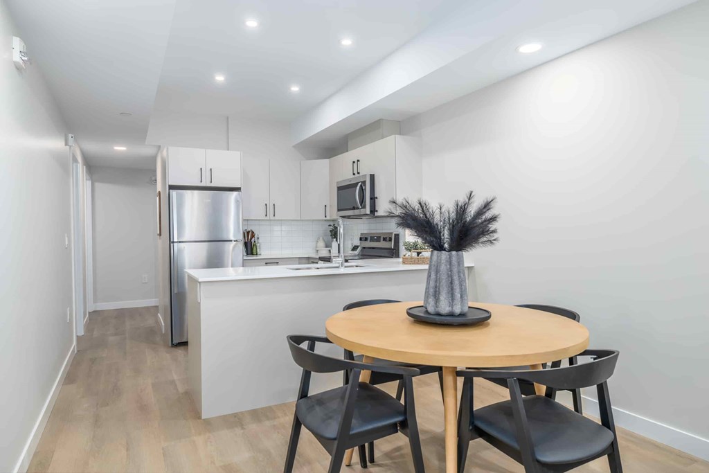 A kitchen with a table and chairs in the foreground.