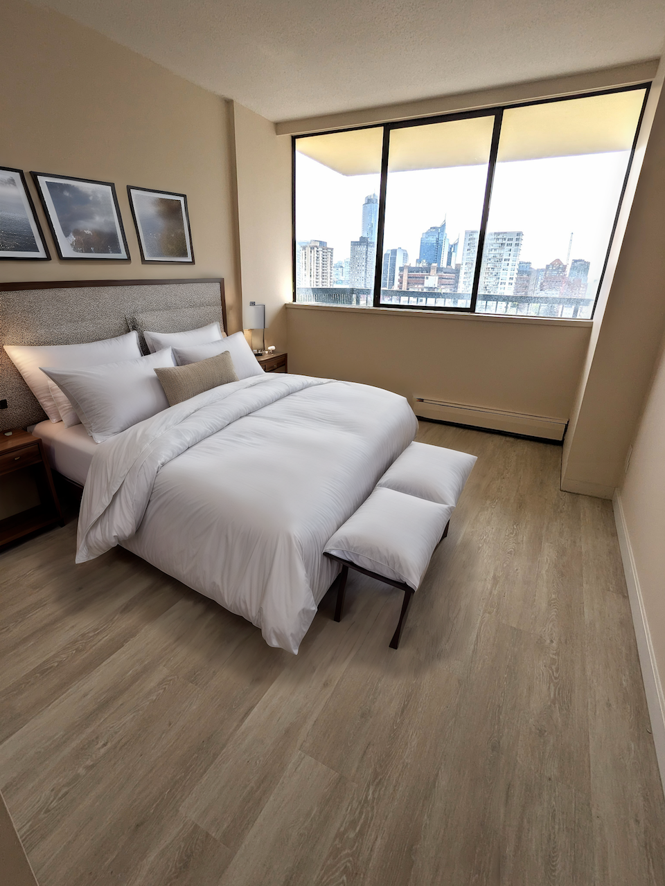 A bedroom with a large bed and a city view through the window.
