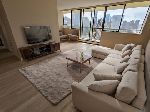 A living room with a large couch, a television, and a coffee table.
