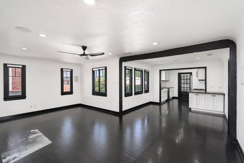 a living room with white walls and a dark wood floor