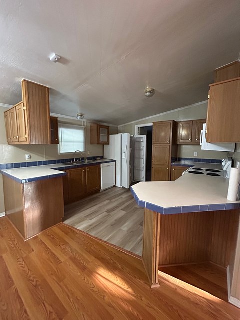 a kitchen with wooden cabinets and a white counter top