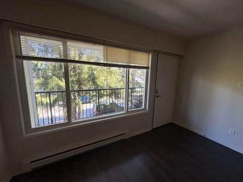 A room with a sliding glass door leading to a balcony.