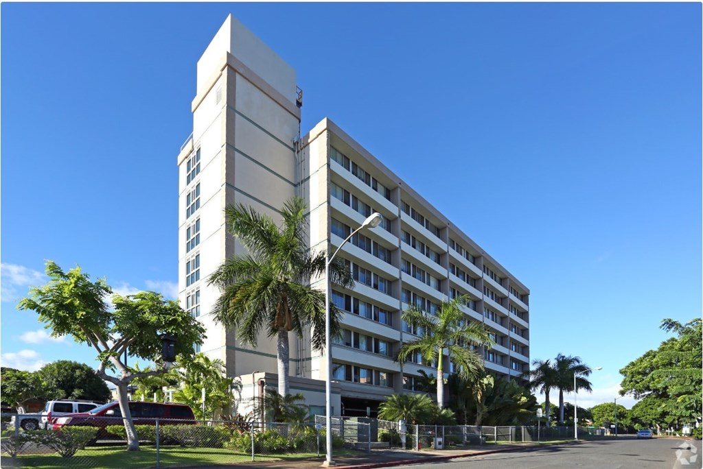 a large white building with palm trees in front of it