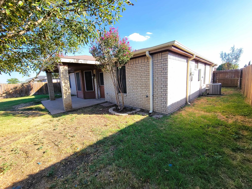 a small brick house with a yard and a tree