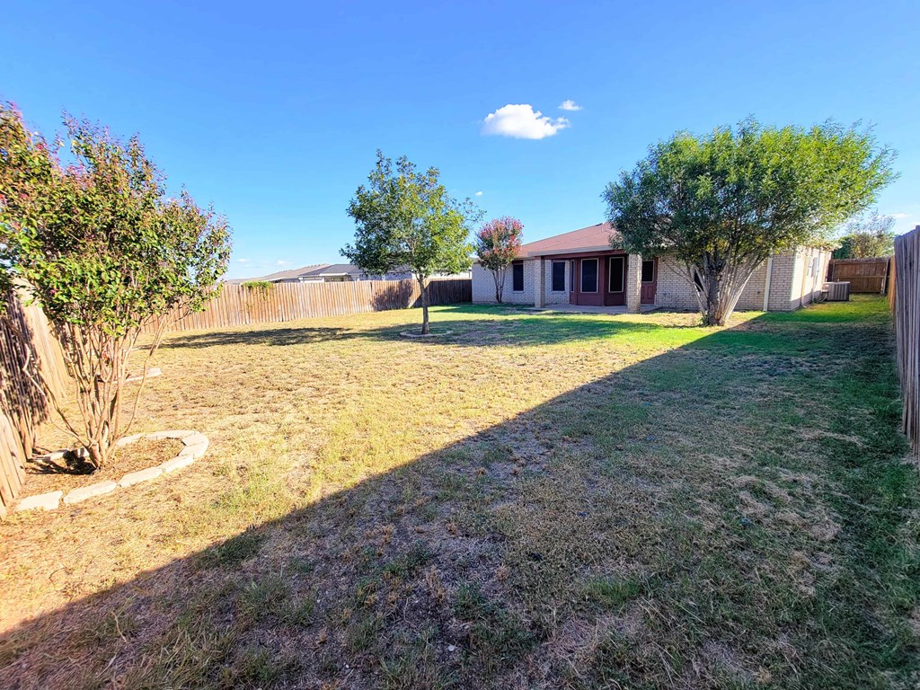 a backyard with a house and a yard with grass and trees