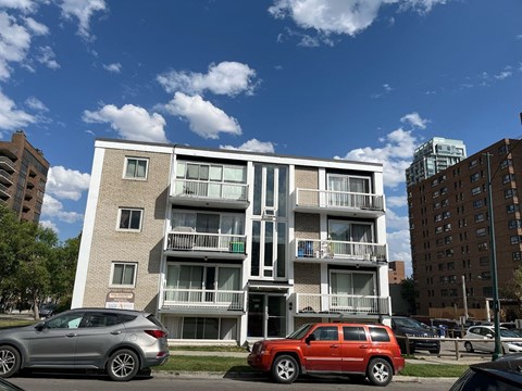 an apartment building with cars parked in front of it