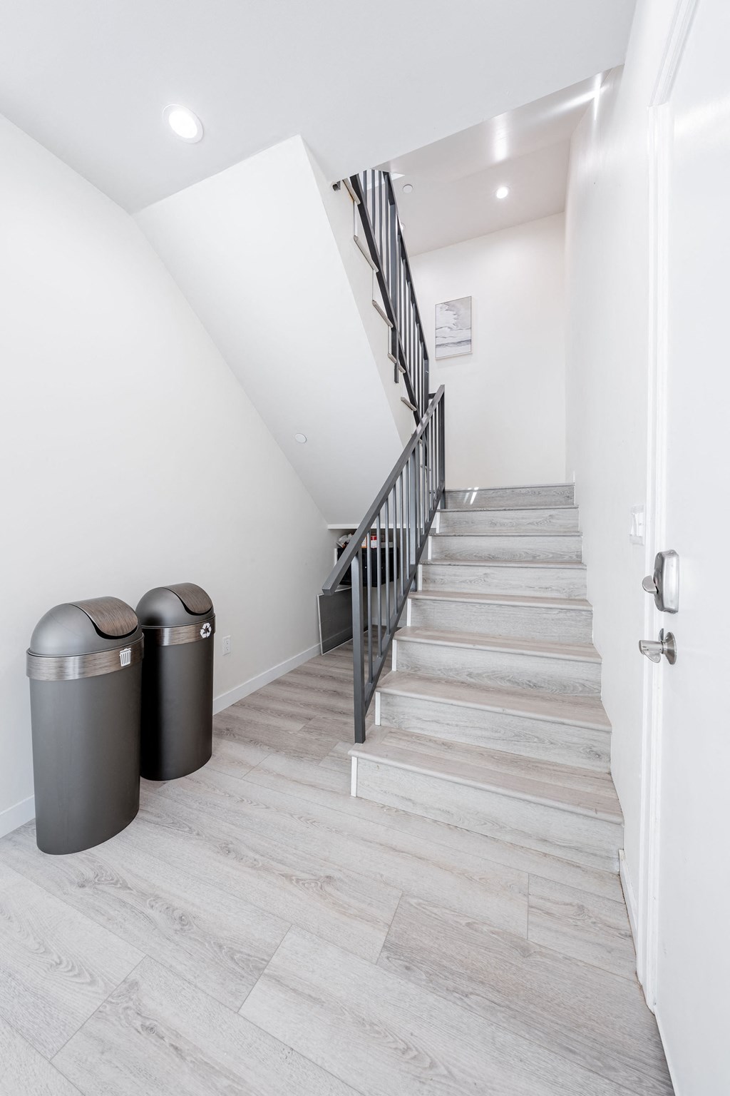 a long staircase leading up to a white room with white walls and a stairwell