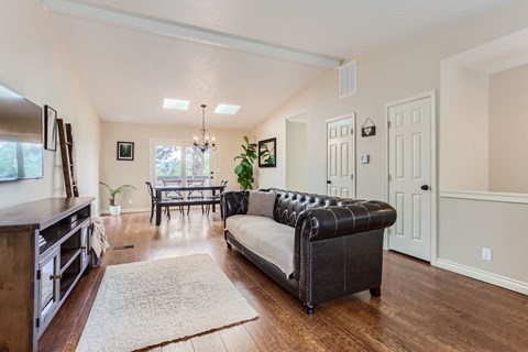 a living room with a leather couch and a dining room table