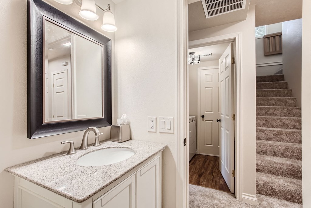 a bathroom with a sink and a mirror and a staircase