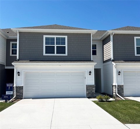 A modern two-story house with a garage door and a driveway.
