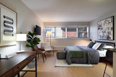 A modern bedroom with a bed, chair, and a desk.