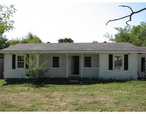 a white house with a porch and a yard