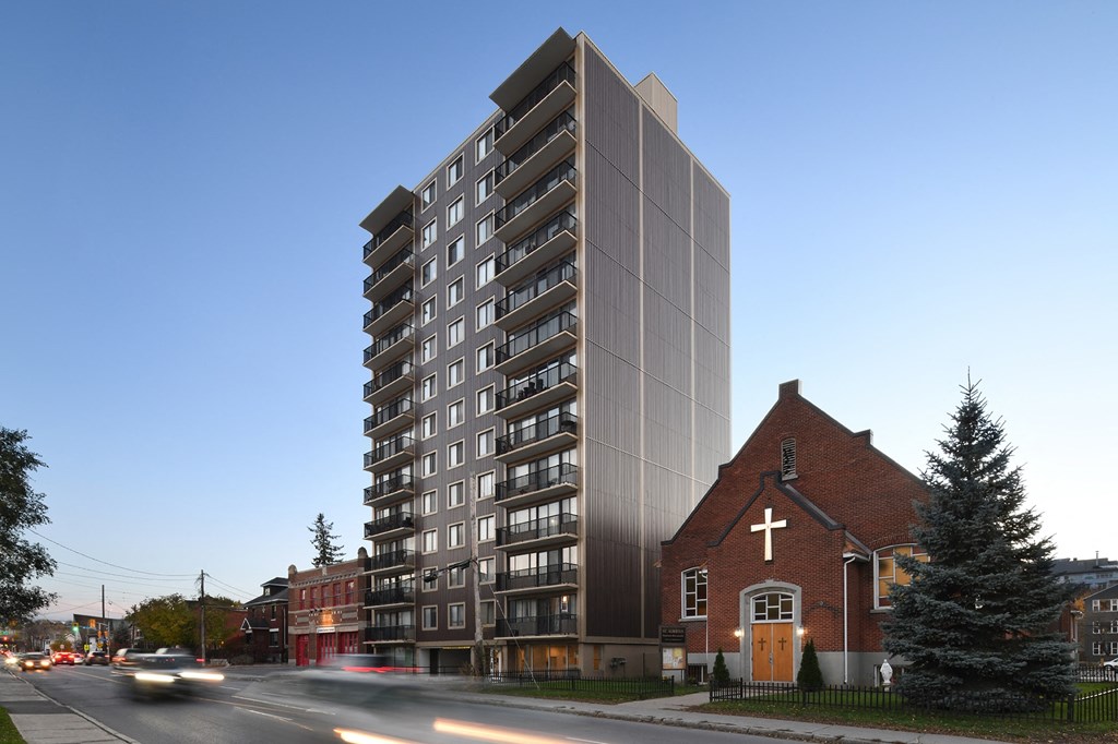 a high rise building next to a church and a street