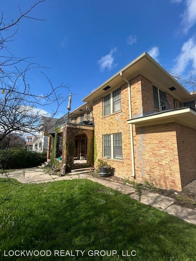 a brick house with a lawn in front of it