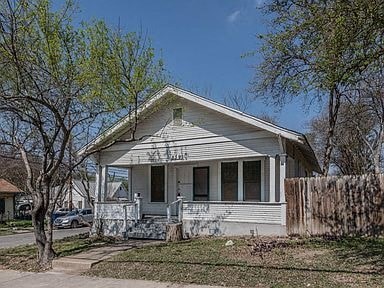 a white house with a porch and some trees