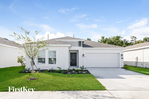 a white house with a lawn and a driveway