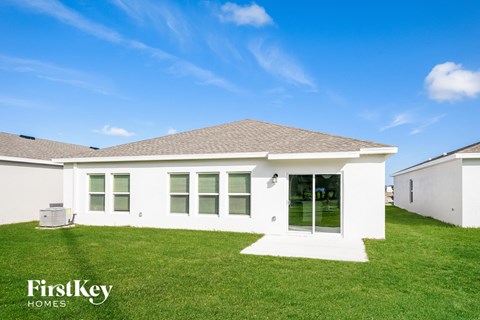 a white house with green grass and a blue sky