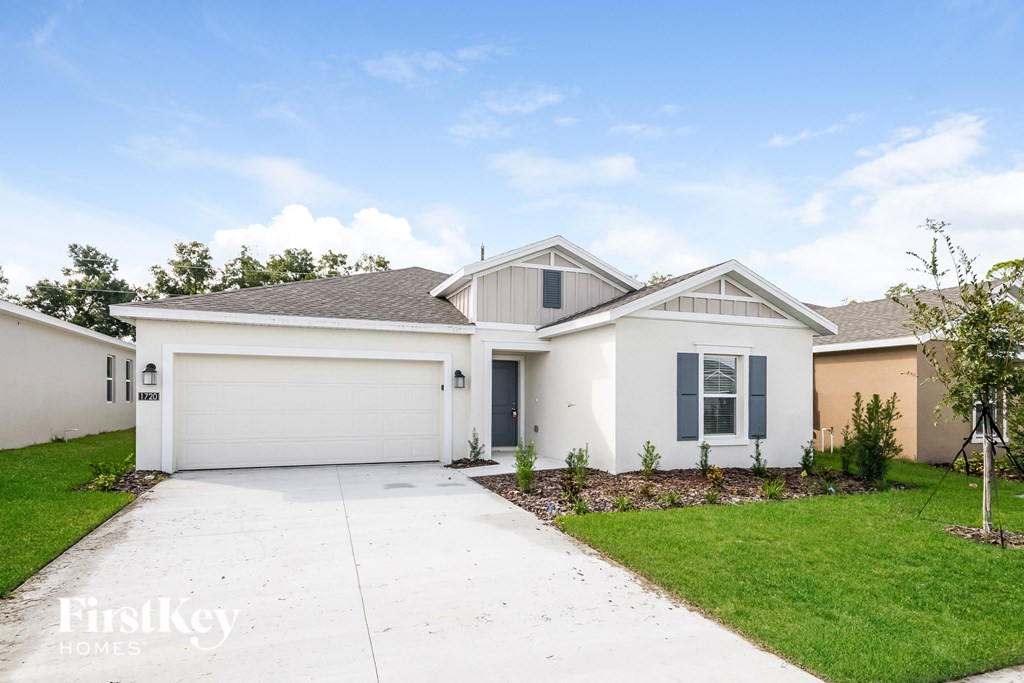 a white house with a driveway and a lawn