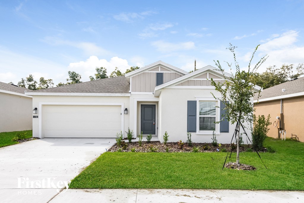 a white house with a lawn and a driveway