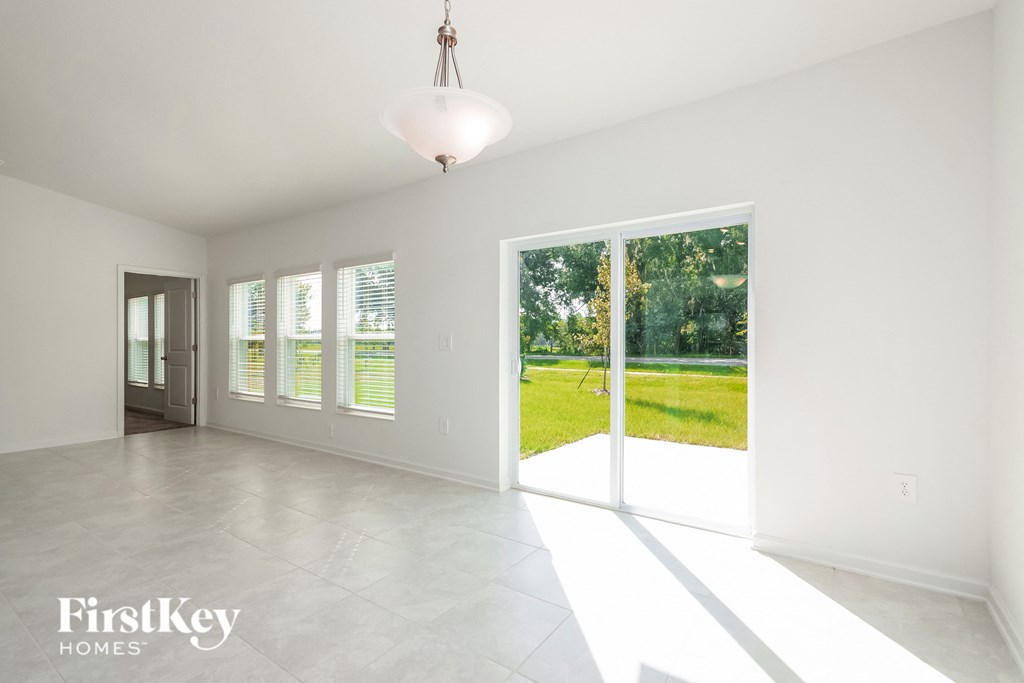 a large empty living room with sliding glass doors to the yard