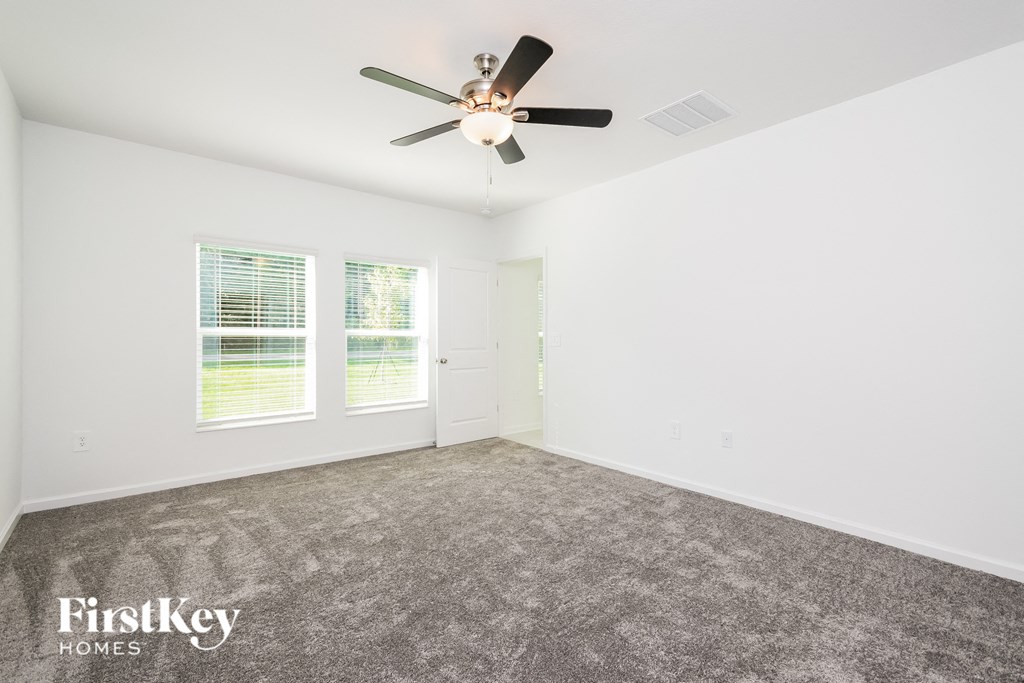 a living room with carpet and a ceiling fan