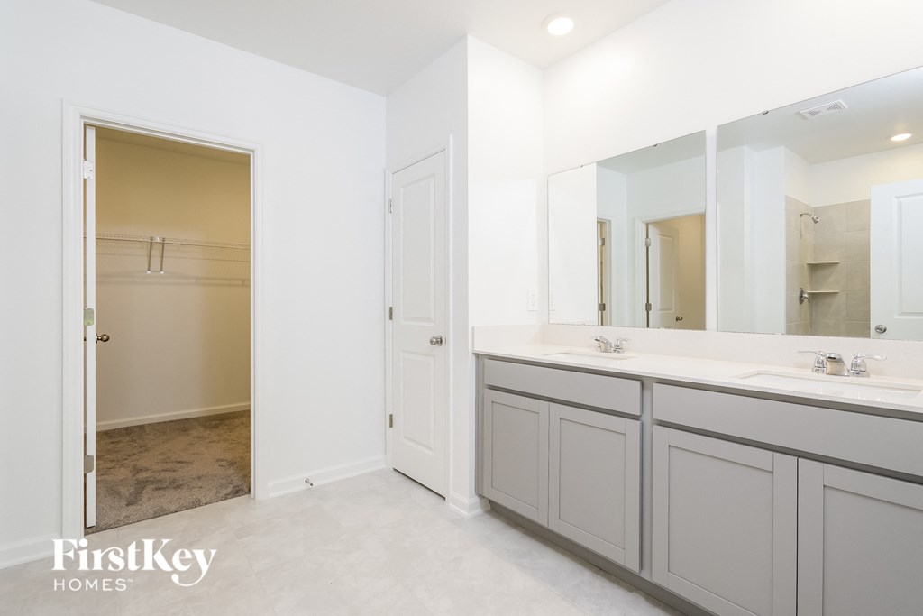 a white bathroom with two sinks and a large mirror