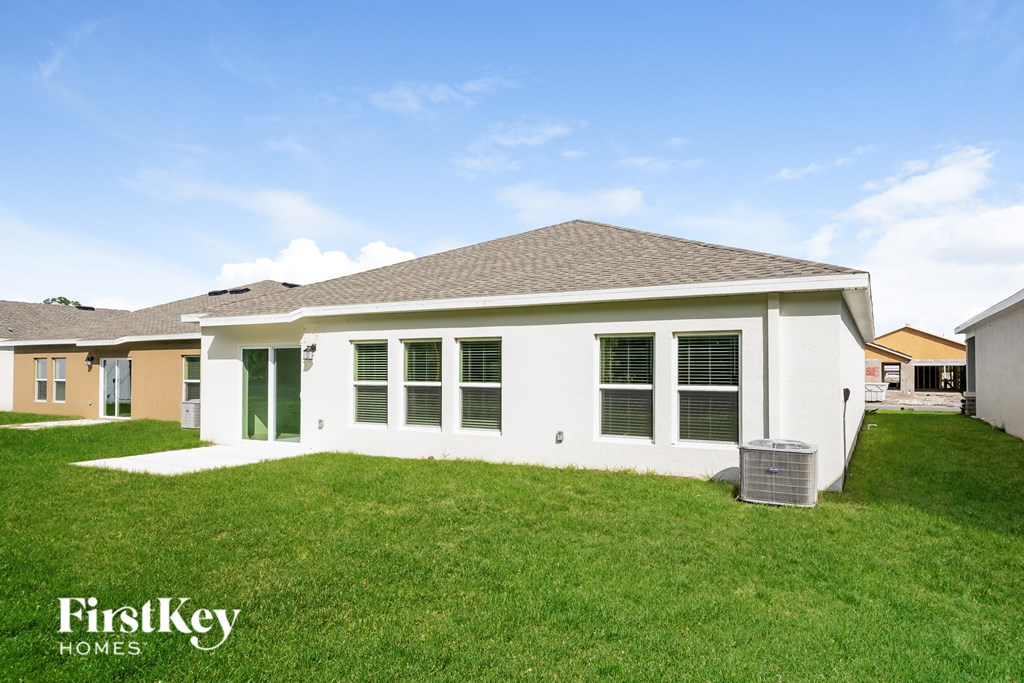 a white house with green shutters and a grass yard