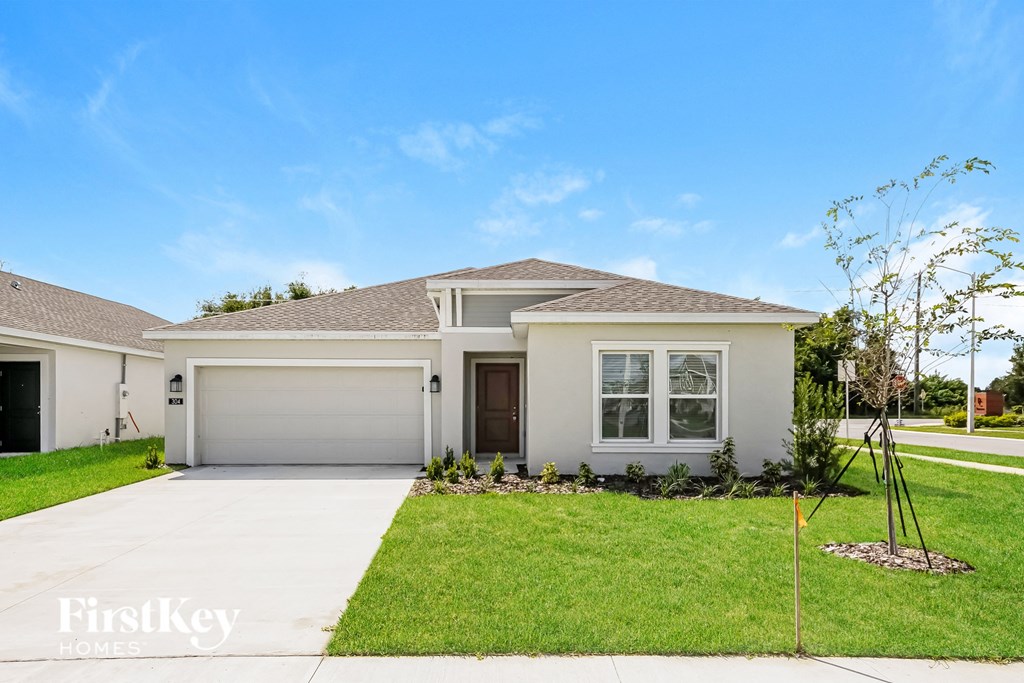 a white house with a lawn and a driveway