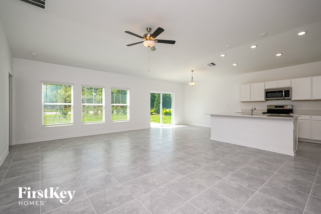 an empty kitchen and living room with a ceiling fan
