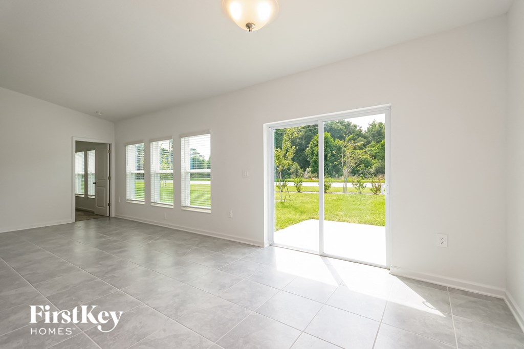 an empty living room with sliding glass doors to a yard